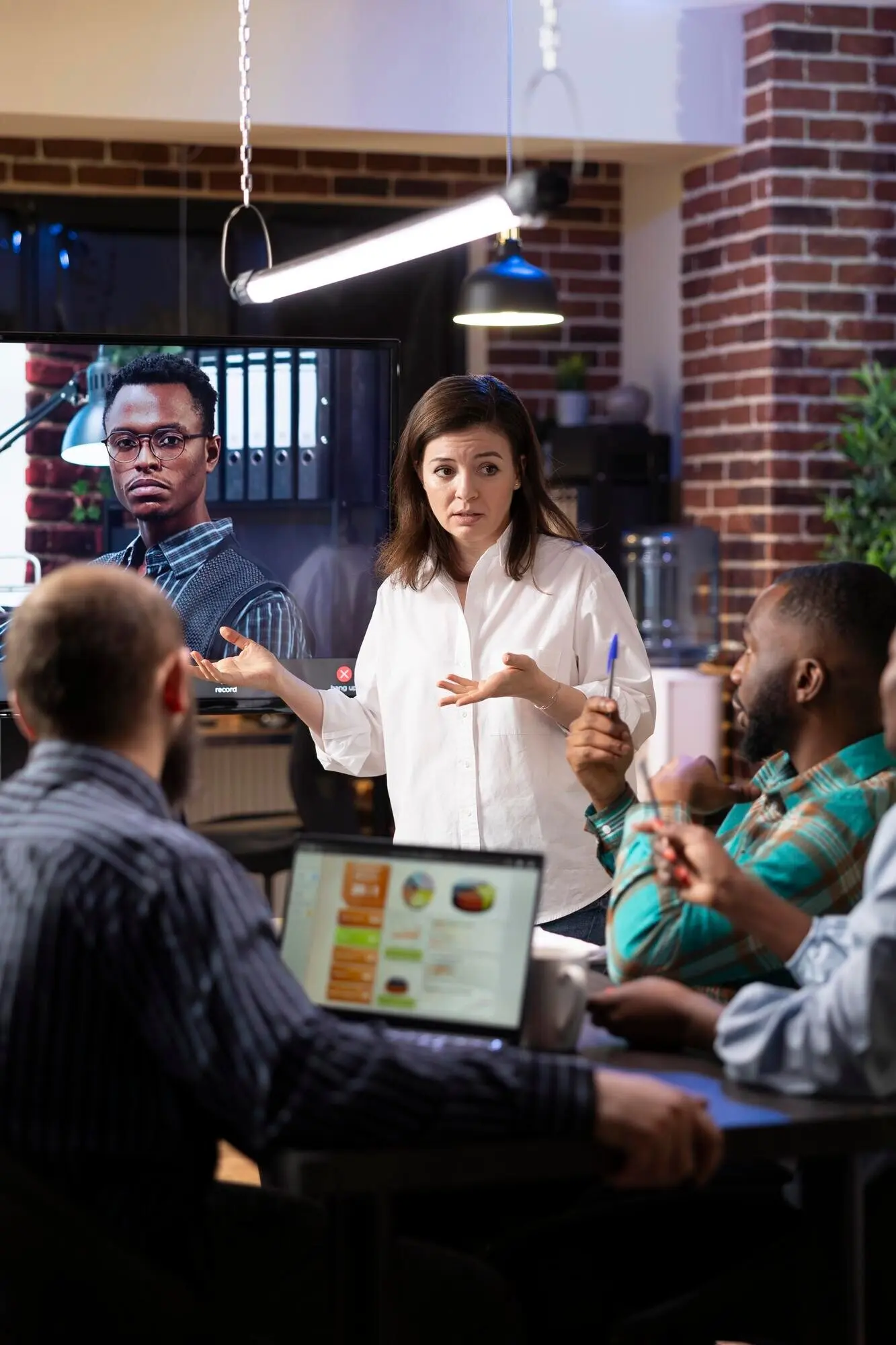 Коллеги, участвующие в виртуальной встрече в офисе.