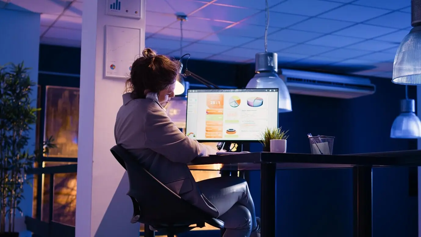 Женщина‑консультант в офисе отвечает на звонок по стационарному телефону.